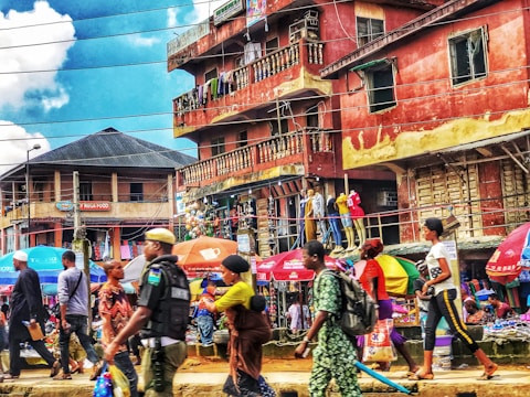 A bustling city street filled with colorful market stalls.