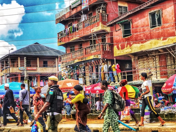 Image of a vibrant market street filled with colorful stalls and happy travelers