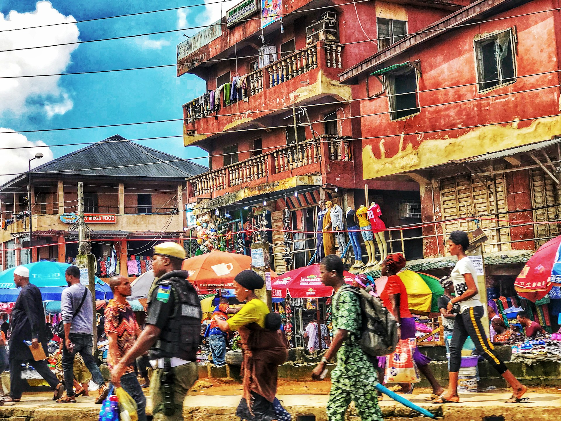 A vibrant travel photo showcasing a colorful street scene filled with lively market stalls and busy locals.