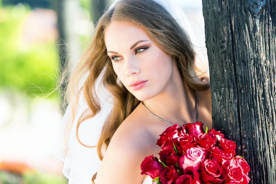 woman in white tank top holding red roses