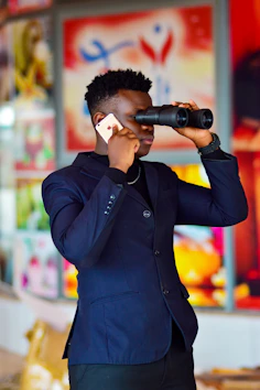 man in black jacket holding black and gray camera