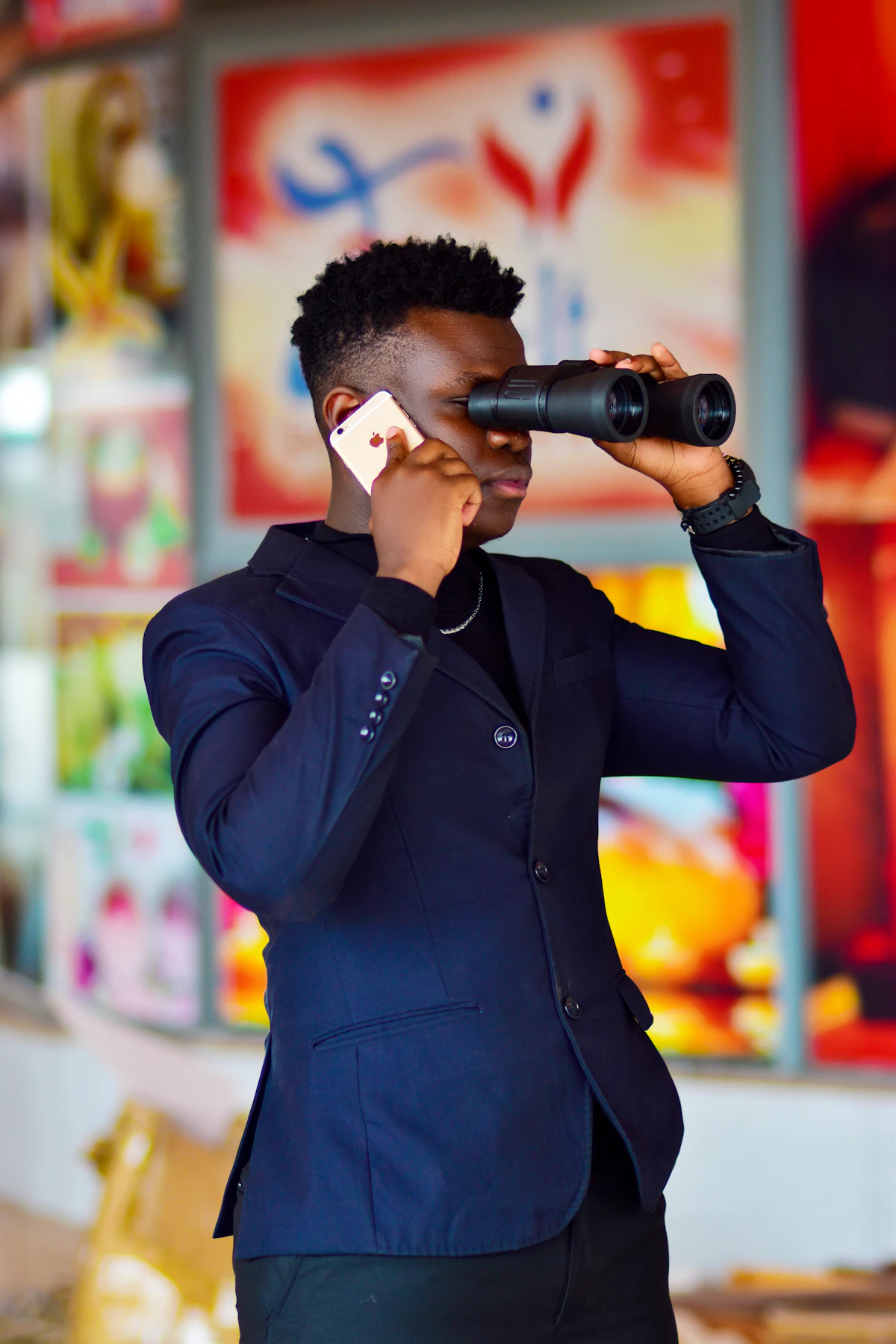 Man in black jacket holding black and gray camera