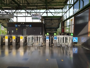 Turnstile gate installed at a building entrance with sleek, light-toned surroundings.