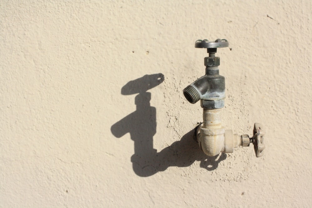 stainless steel faucet on white wall