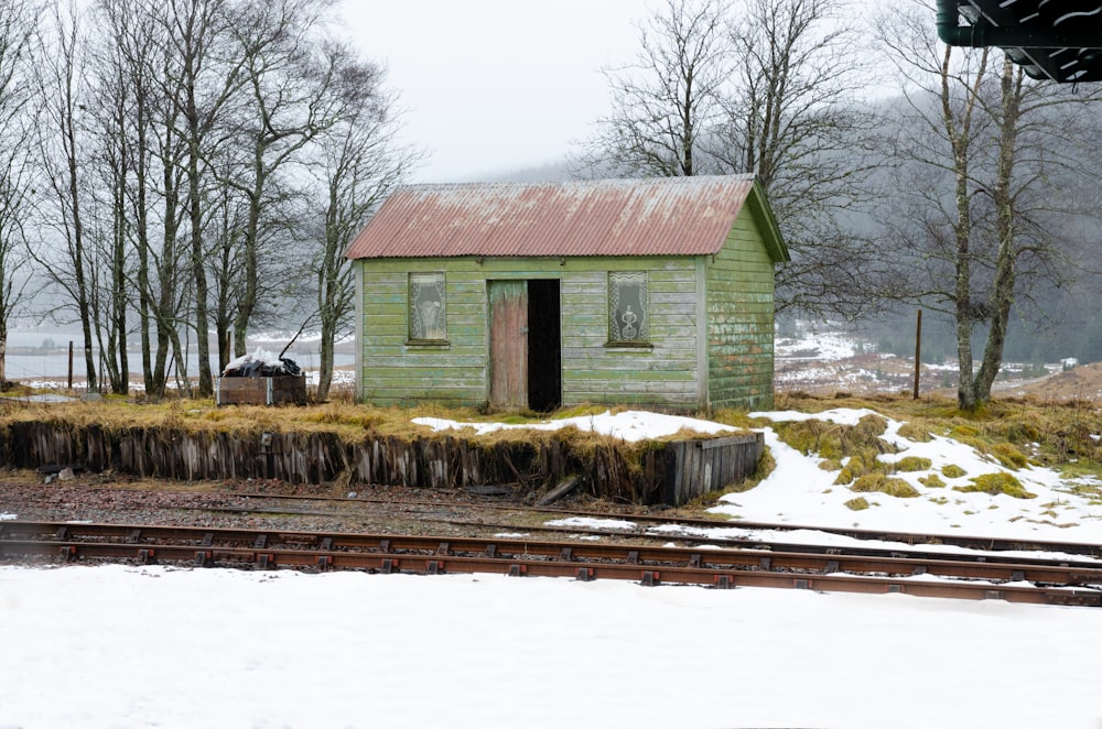 brown wooden house near bare trees during daytime