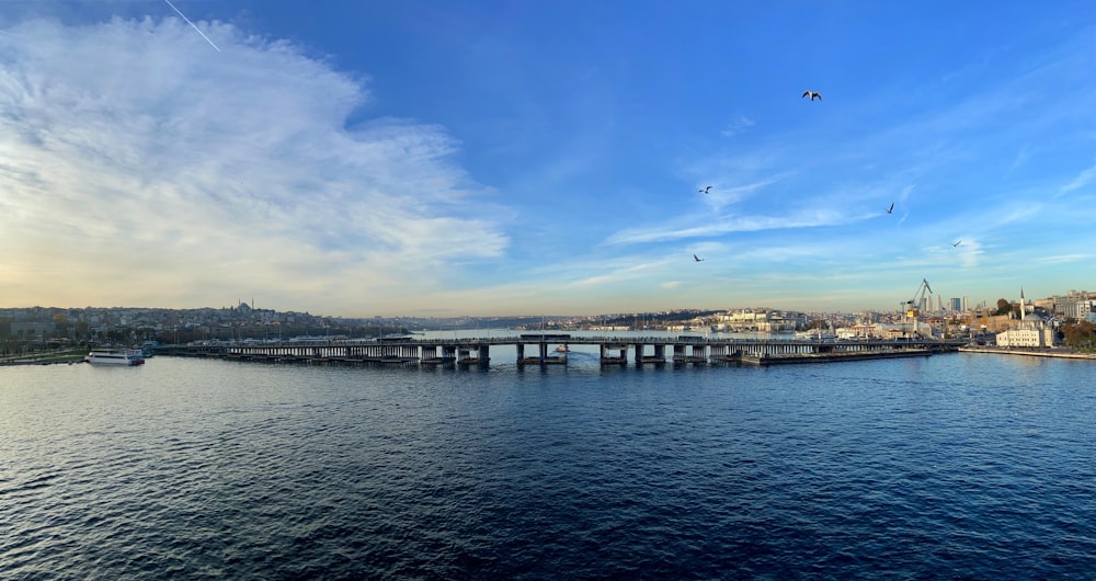 Cuerpo de agua cerca del puente bajo el cielo azul durante el día