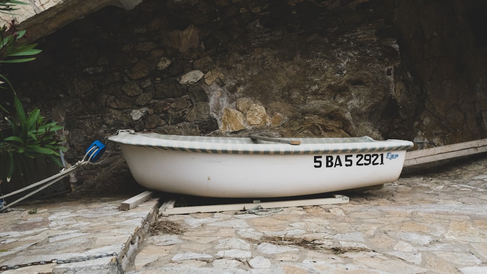 a white boat sitting on top of a stone floor