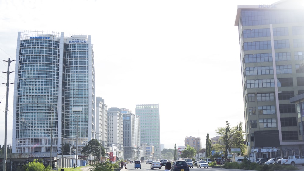 cars parked on parking lot near high rise buildings during daytime