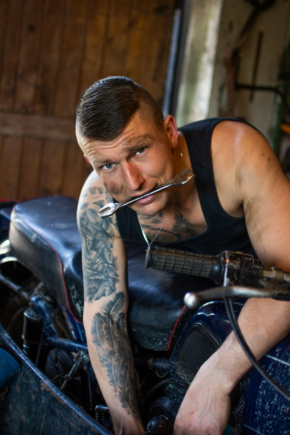 man in black tank top playing guitar