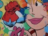 A vibrant graffiti artwork featuring a comic-style depiction of a close-up female face with bold lipstick and an exaggerated eye. A red-gloved fist is prominent, suggesting a superhero motif. The background is filled with colorful splashes and dots in shades of blue, green, pink, and orange.