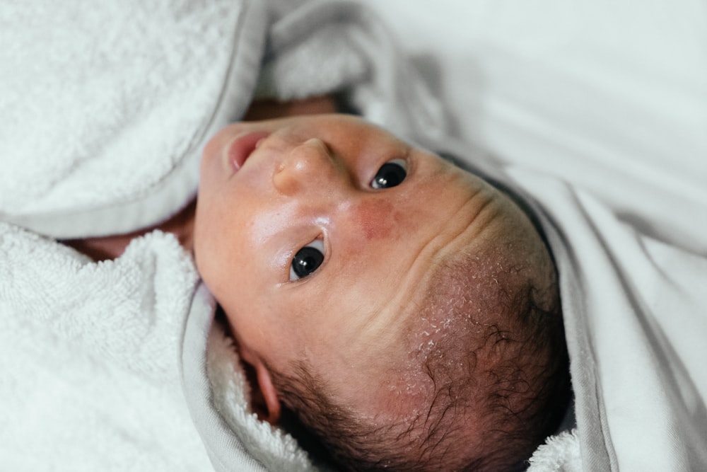 baby covered with white blanket