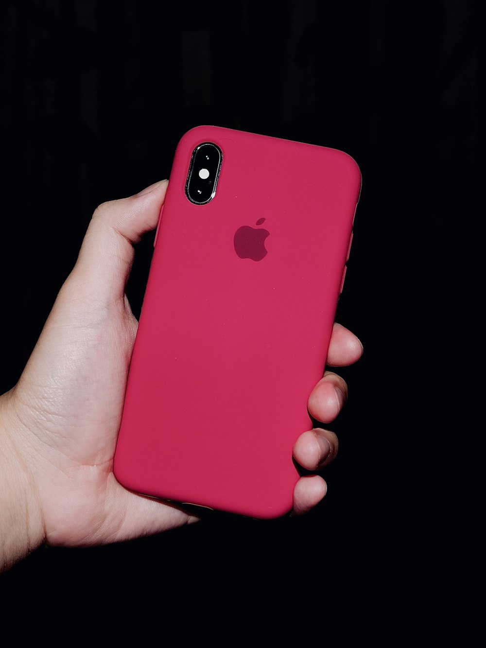 person holding iphone with red case