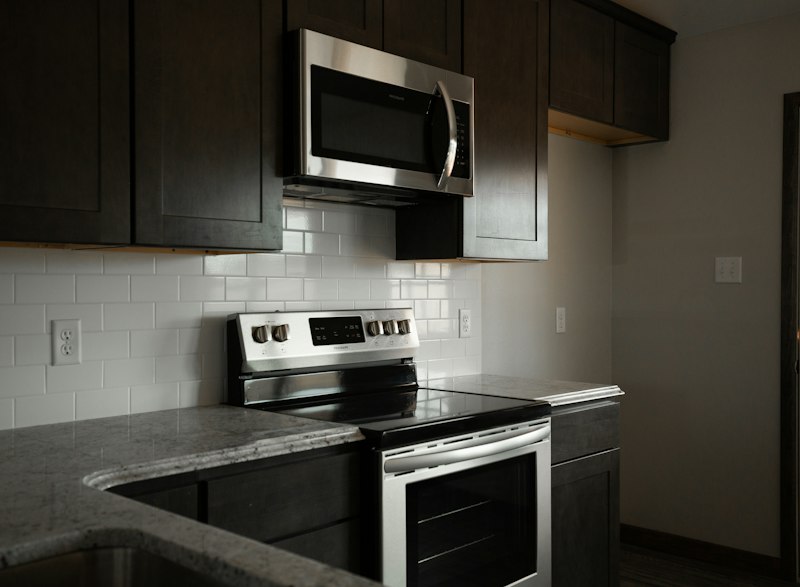 Modern silver and black microwave oven in a kitchen, the direct descendant of Percy Spencer's 1947 Radarange