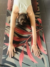 woman in white shirt lying on black and red stripe hammock