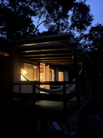 A hammock swinging gently on a rustic porch overlooking the slow-moving river.