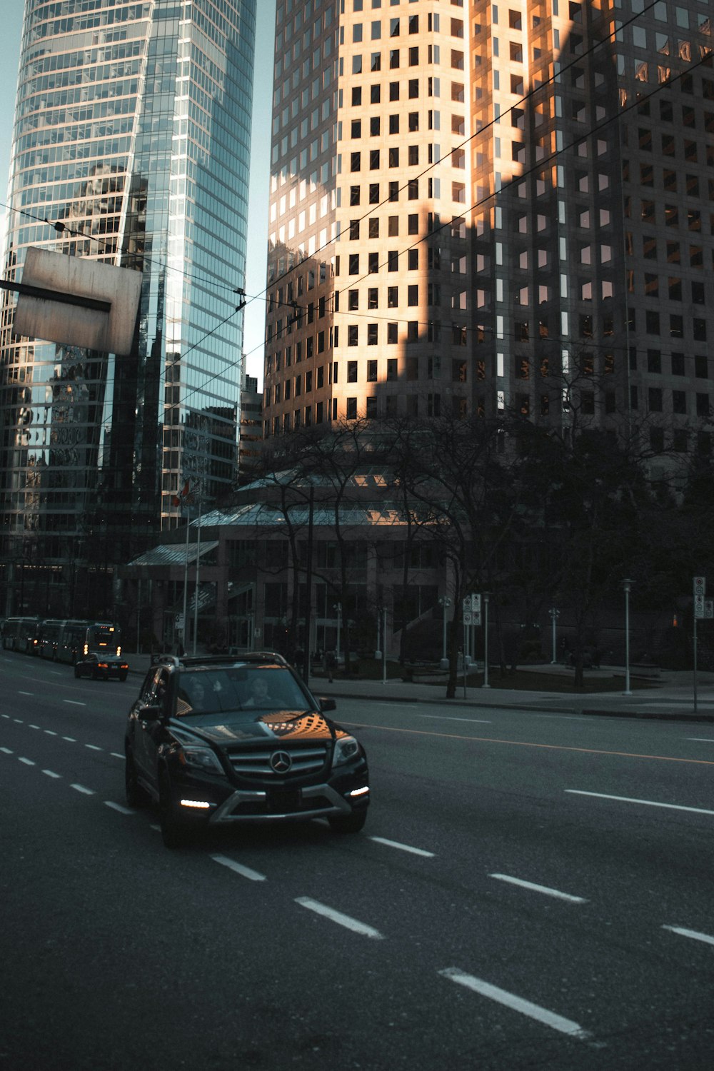 black car on road near high rise buildings during daytime