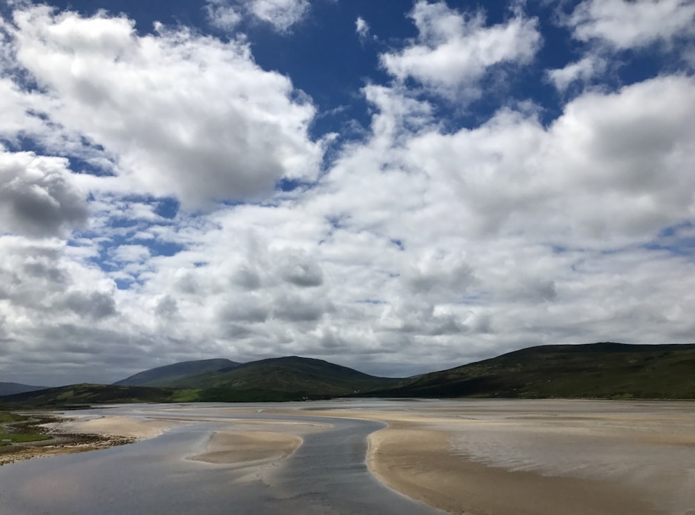 white clouds over brown field