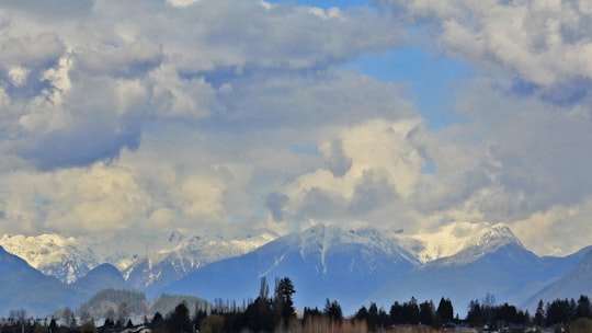 green trees and white clouds on mountain in Pitt Meadows Canada