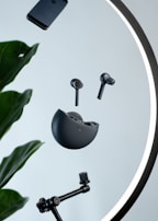 Holobuds floating mid-air with subtle holographic light trails against a dark minimalist background.