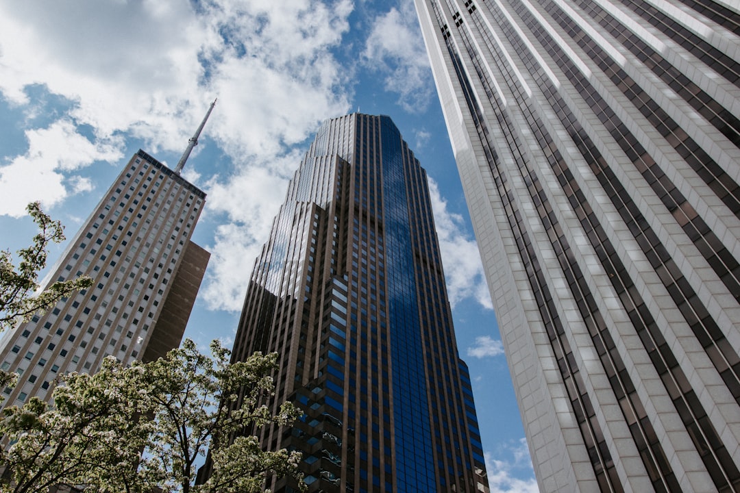 low angle photography of high rise buildings under white clouds and blue sky during daytime