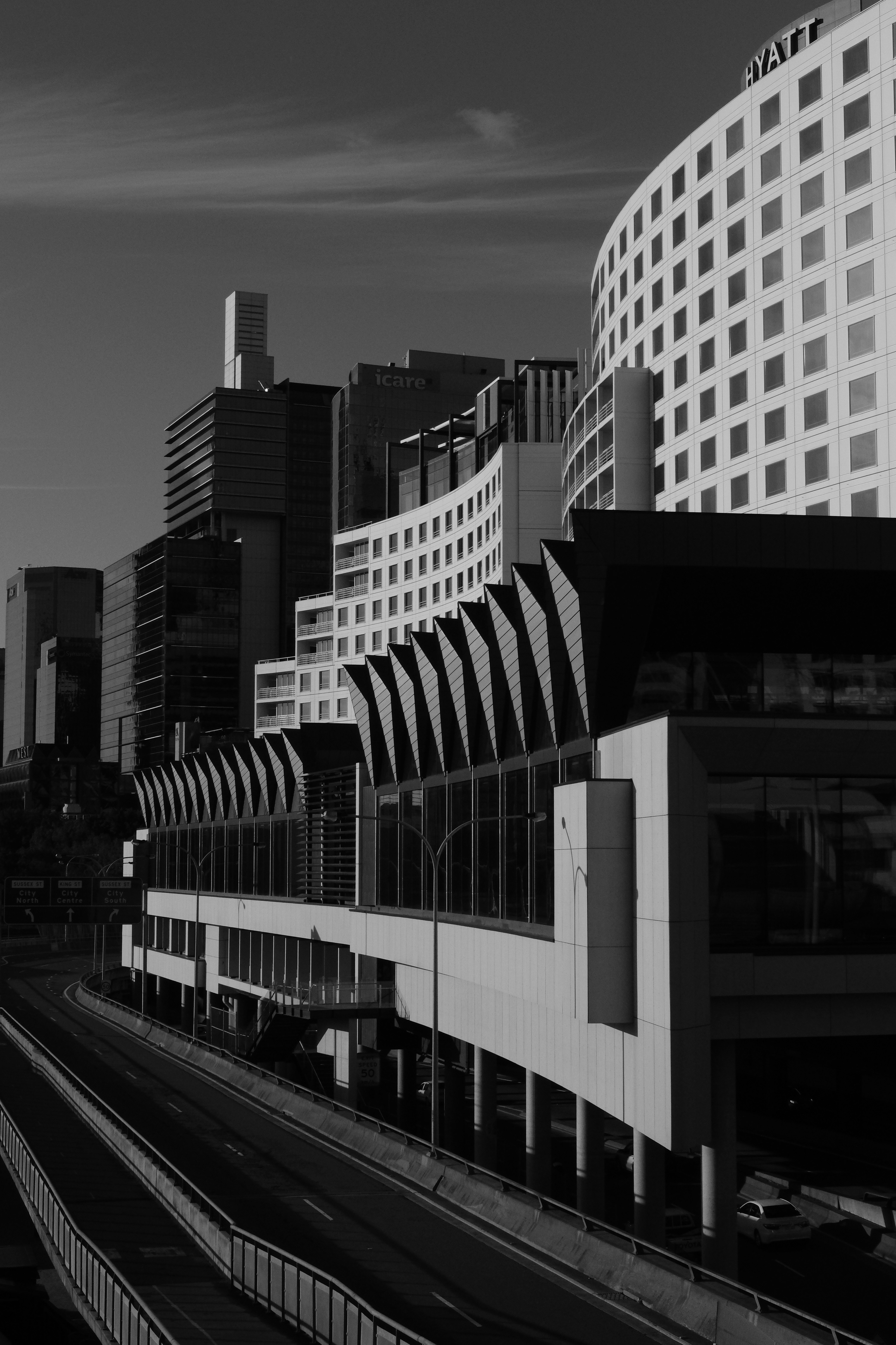 grayscale photo of train rail near building