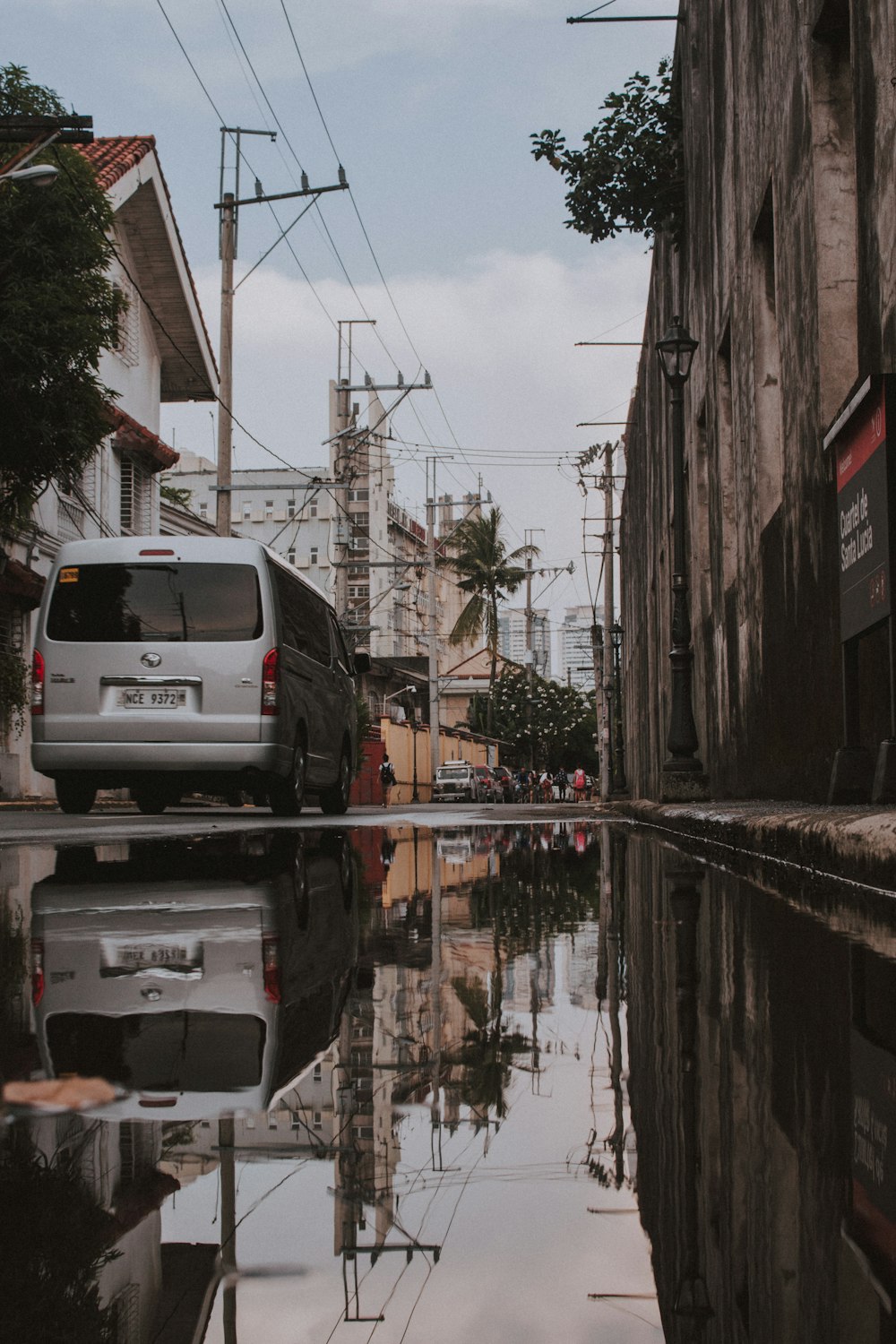 white car parked beside brown building during daytime