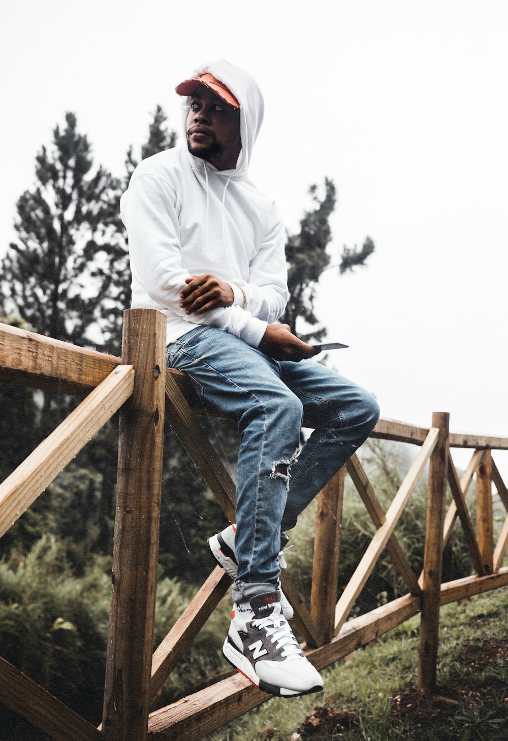 a man riding on top of a wooden fence