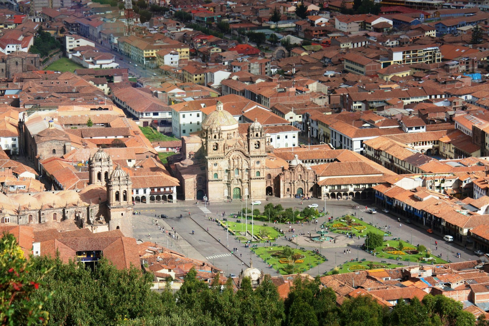 Cusco's Plaza de Armas and the Church of La Compañía seen from the hillside above terracotta rooftops