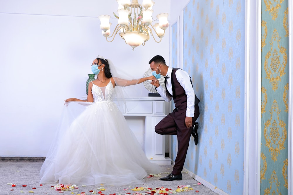 man in black suit kissing woman in white wedding dress