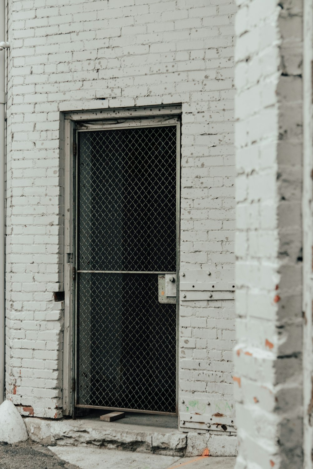 grey wooden door with black metal door lever