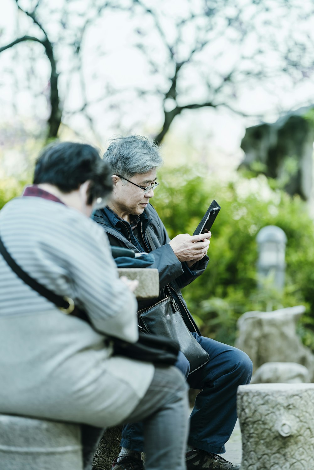 Mann in schwarzer Jacke mit schwarzem Smartphone