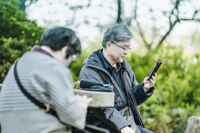man in black jacket holding black smartphone