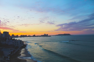 Scenic coastal view with vibrant sunset over calm ocean waters.