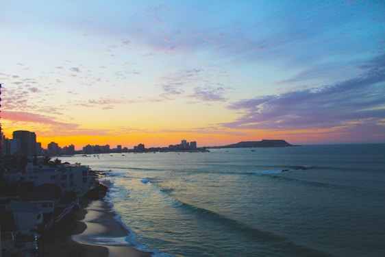 Scenic coastal view with vibrant sunset over calm ocean waters.