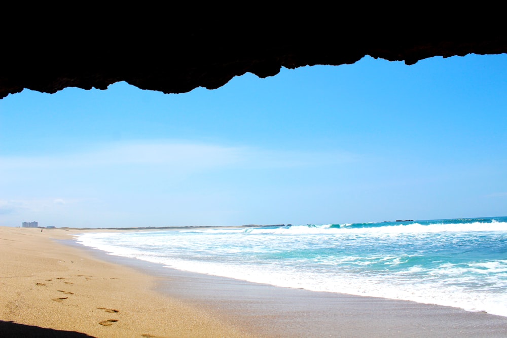 brown sand beach under blue sky during daytime