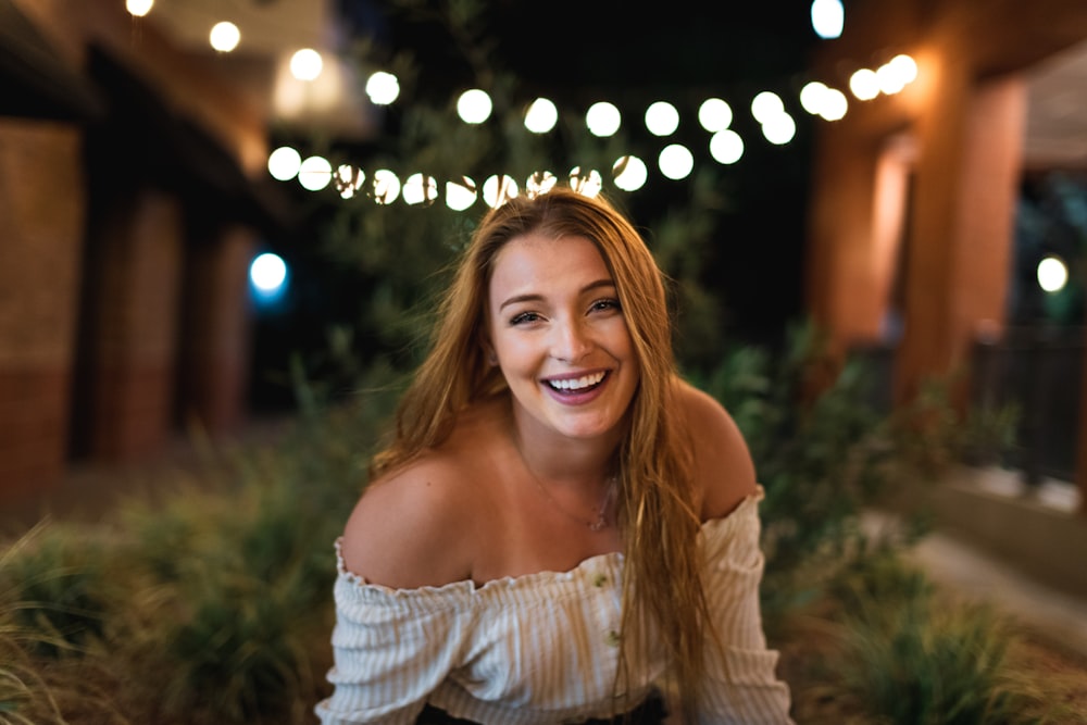 woman in white off shoulder dress smiling