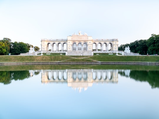 white and brown concrete building near body of water during daytime in Schönbrunner Schloss Park Austria