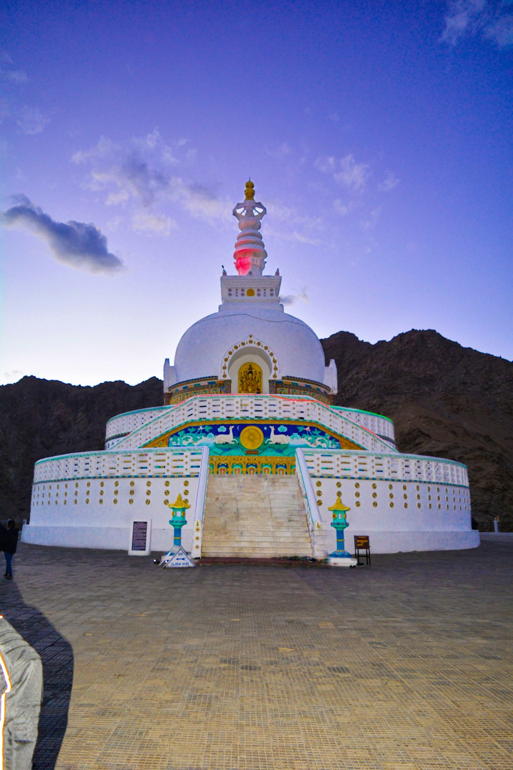 white green and yellow concrete building near mountain under blue sky during daytime