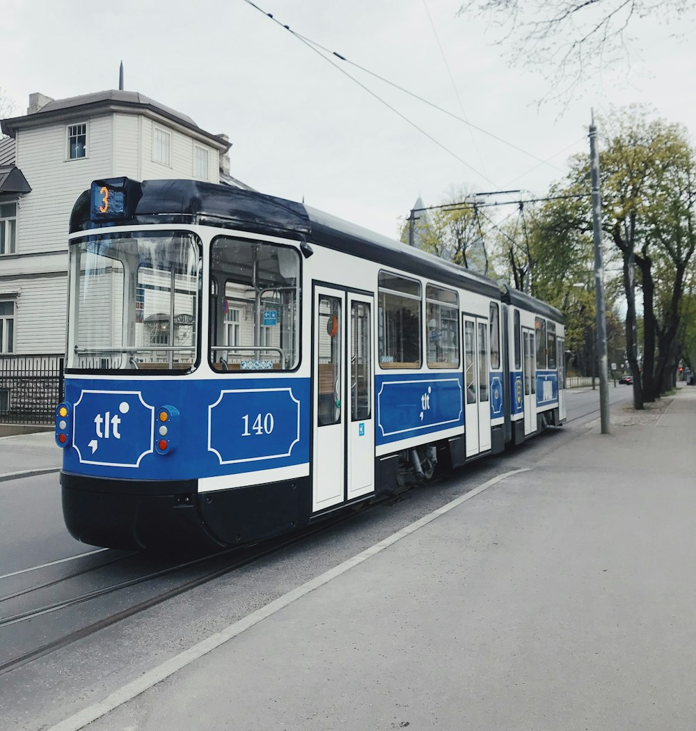 Train blanc et bleu sur la voie ferrée pendant la journée