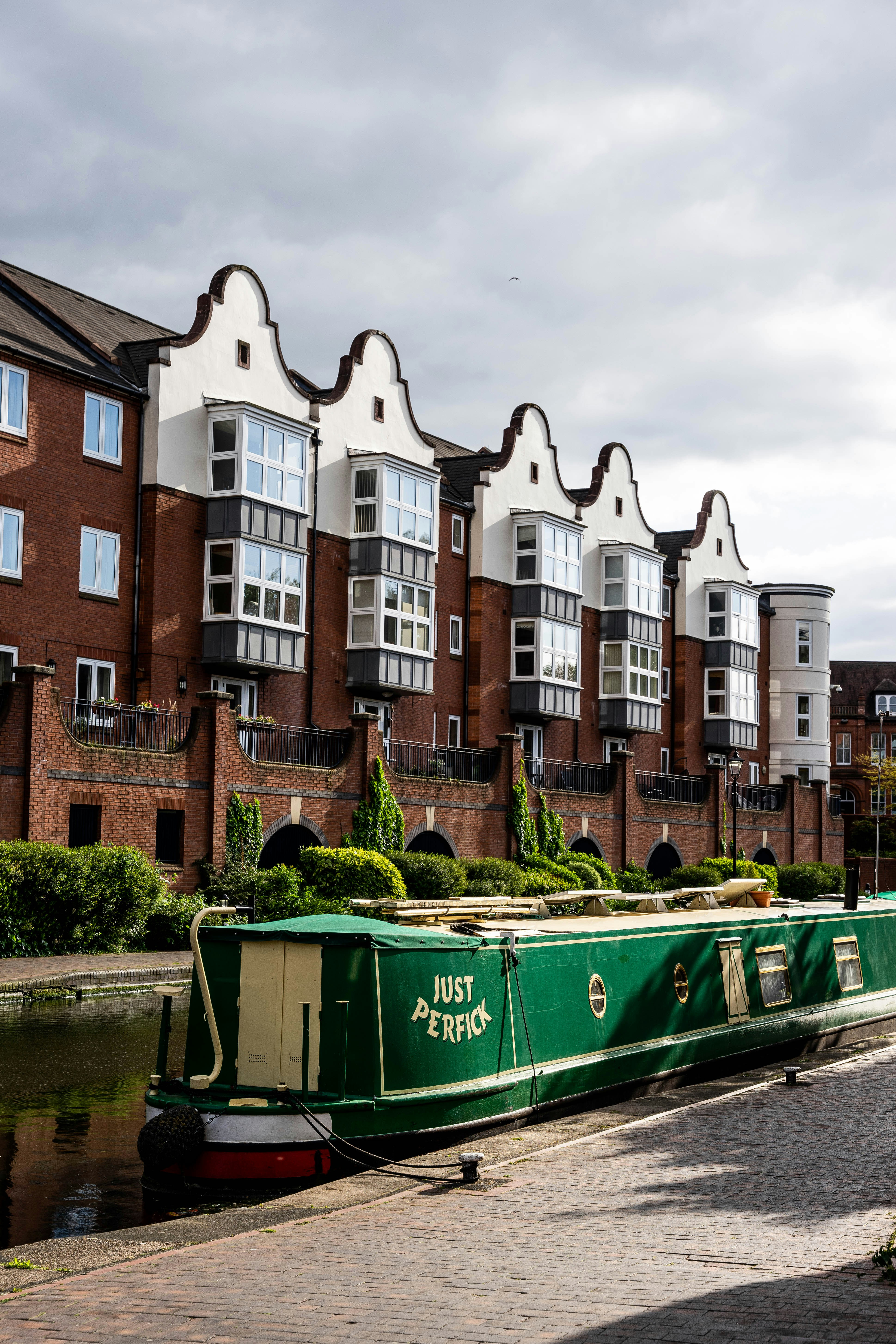 green boat on water near brown concrete building during daytime