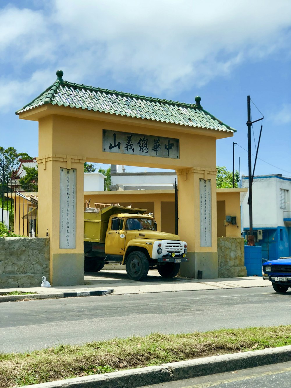 yellow and black car parked beside brown concrete building during daytime