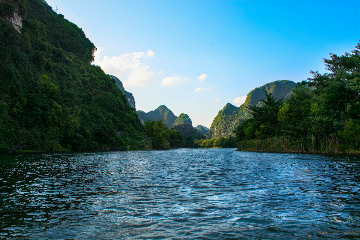 Clear river winding between forested limestone karst mountains