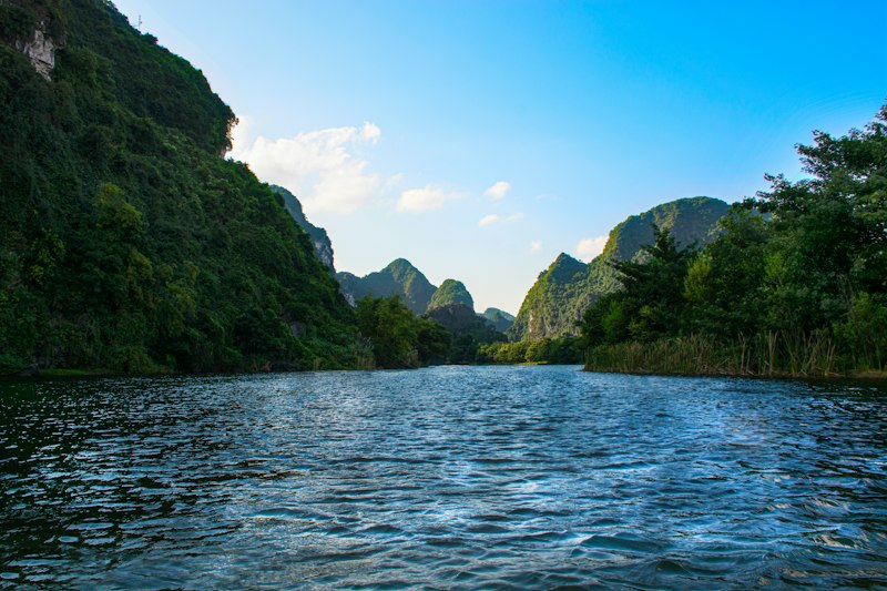 Green limestone karst peaks rising above a river valley in Vietnam