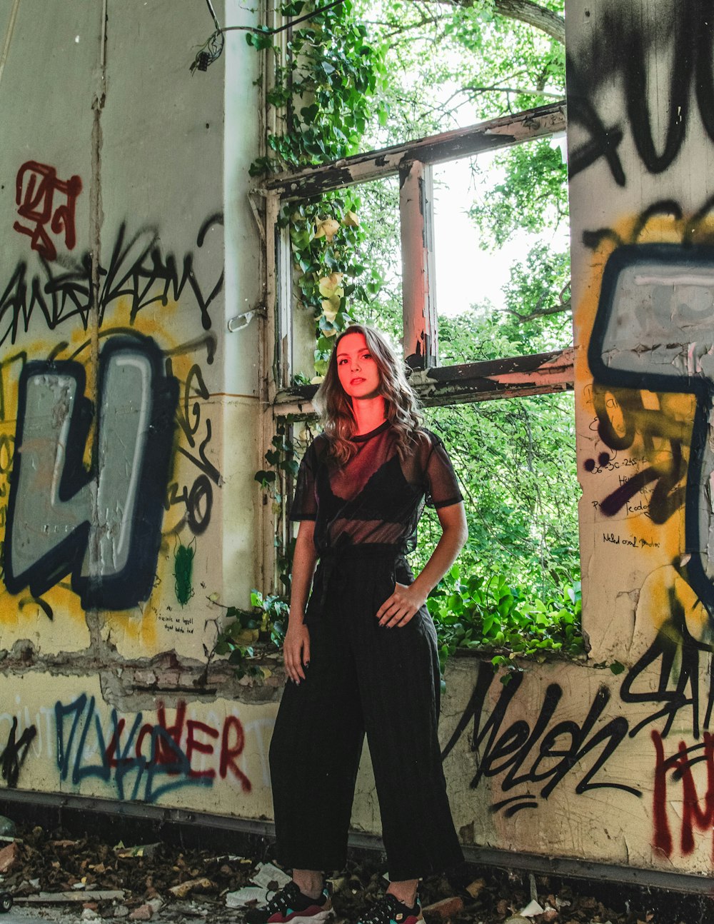 woman in black dress standing beside wall