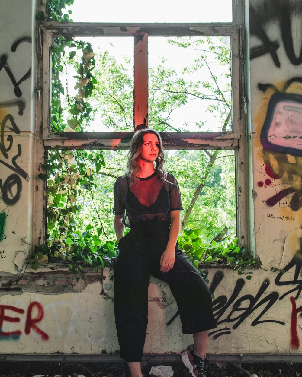 woman in black shirt and black pants standing near brown wooden post