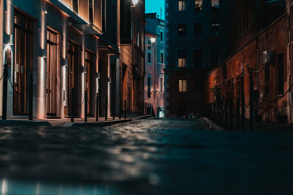 empty street between brown concrete buildings during daytime