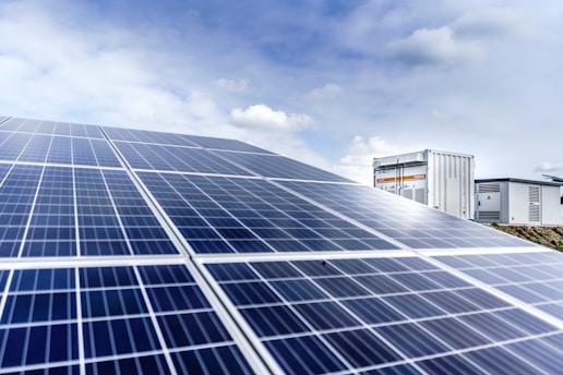 blue and silver solar panels, sky and clouds background.