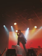 man in black shirt singing on stage