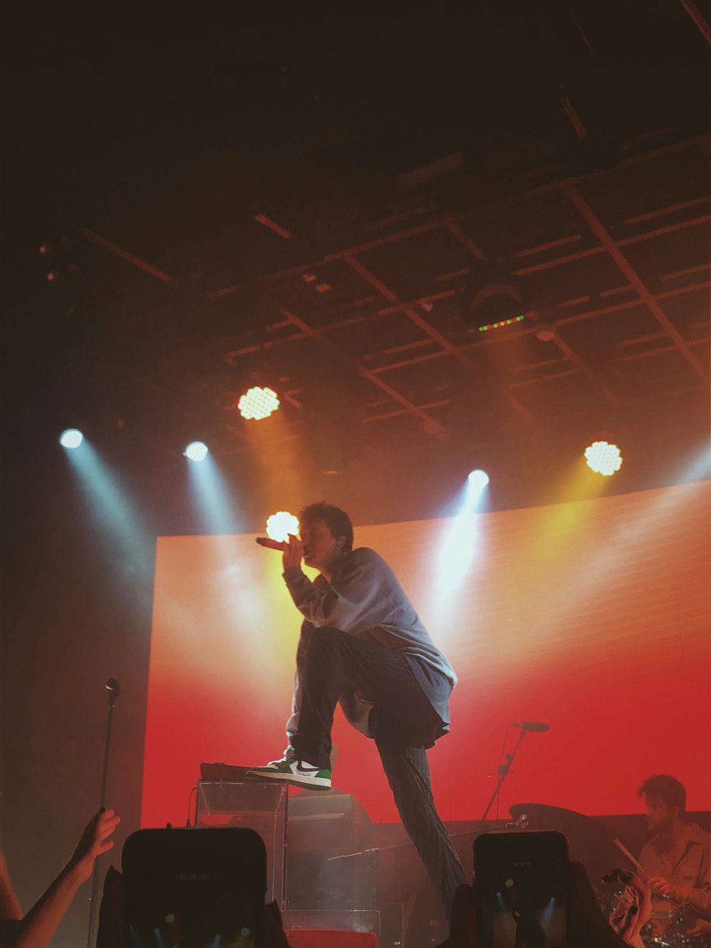 man in black shirt singing on stage