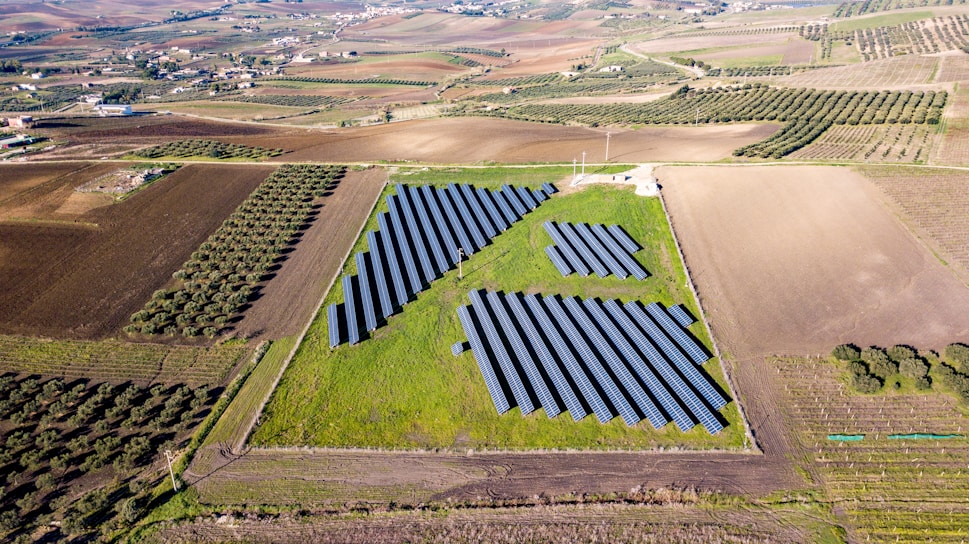A vibrant aerial view of a smart eco-farm with neat rows of organic crops and solar panels.